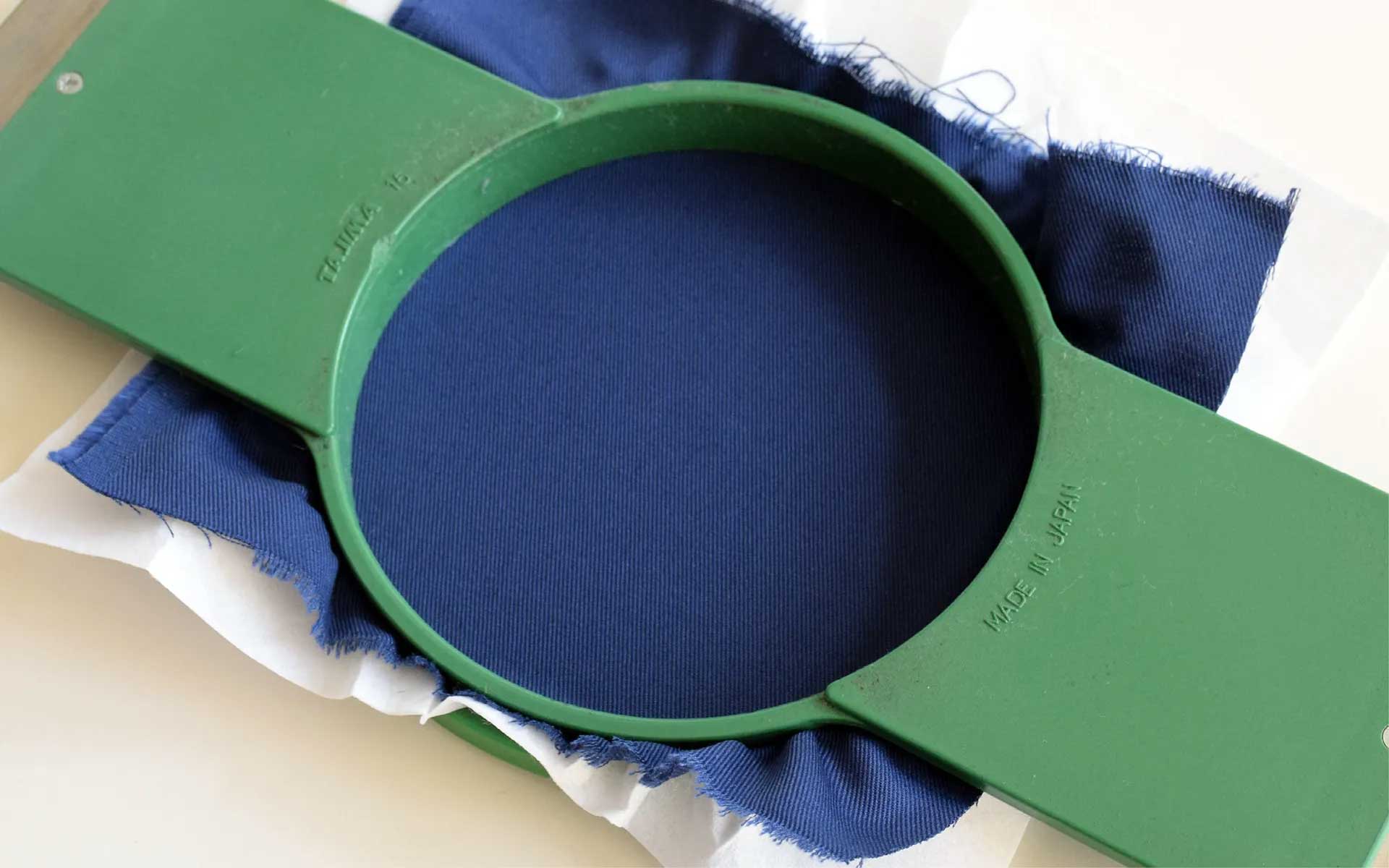 Fabric and embroidery backing stretched in frame